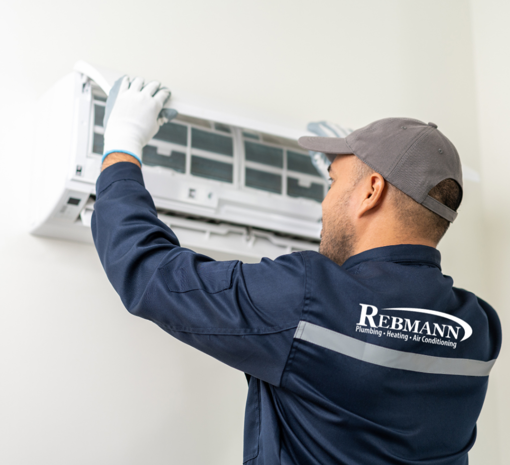 Uniformed Rebmann technician working on a wall-mounted mini-split unit